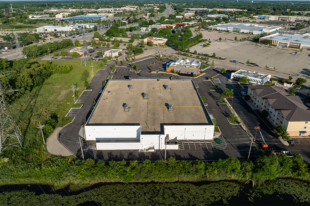 Drone image above Ashley Furniture Homestore and Texas Roadhouse near Gurnee Mills parking lot renovated by Corebuilt Contracting with landscape plan and green grass in Gurnee Illinois